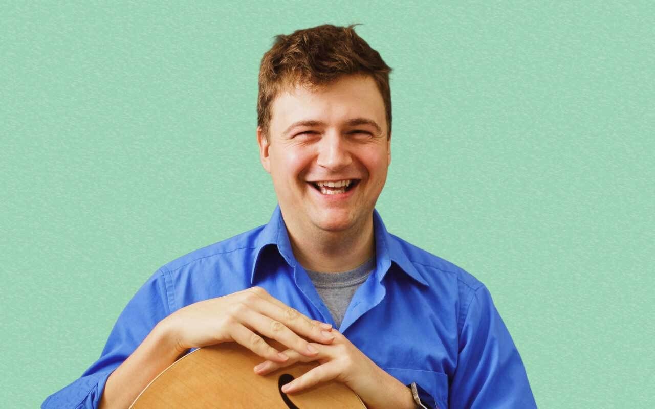 Marc-Andre Seguin smiling with his guitar